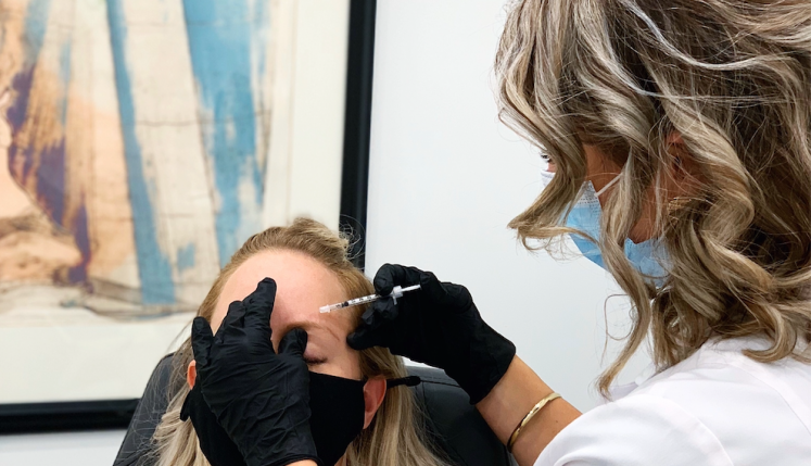 A clinician administers Baby Botox to a patient’s forehead during a preventative Botox treatment at Yazdani Aesthetics, with both wearing masks.